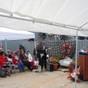 Description: El Cerrito Garden Club member Barbara Post speaks at the dedication of a Blue Star Marker by the El Cerrito Garden Club, in cooperation with the Richmond Museum of History, at the SS Red Oak Victory in Richmond, Memorial Day, May 28, 2012. Other members of the club sit in the first two rows. Holding the guitar is Jun Simundo, an El Cerrito postman, who performed the 'Star Spangled Banner' and 'America the Beautiful.'